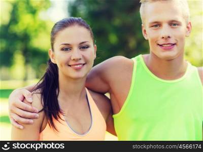 fitness, sport, friendship and healthy lifestyle concept - group of happy teenage friends or sportsmen couple hugging outdoors