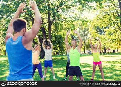 fitness, sport, friendship and healthy lifestyle concept - group of happy teenage friends or sportsmen exercising at boot camp