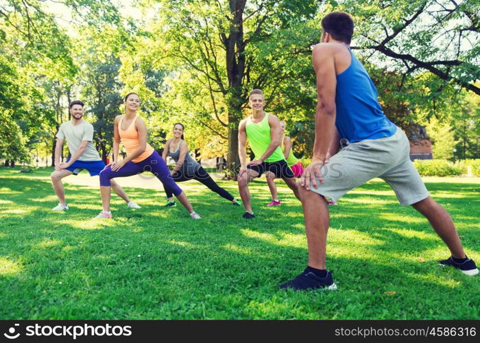 fitness, sport, friendship and healthy lifestyle concept - group of happy teenage friends or sportsmen exercising and doing lunge at boot camp