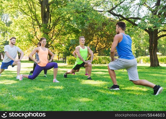 fitness, sport, friendship and healthy lifestyle concept - group of happy teenage friends or sportsmen exercising and doing lunge at boot camp