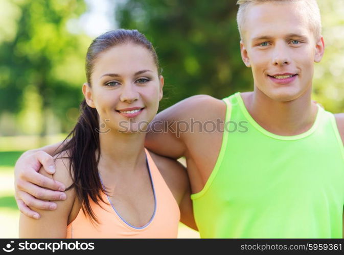 fitness, sport, friendship and healthy lifestyle concept - group of happy teenage friends or sportsmen couple hugging outdoors