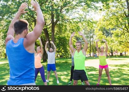 fitness, sport, friendship and healthy lifestyle concept - group of happy teenage friends or sportsmen exercising at boot camp