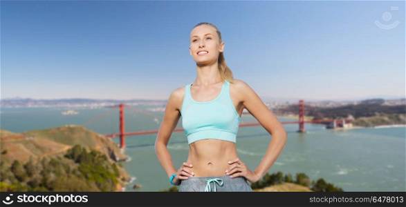 fitness, sport, friendship and healthy lifestyle concept - happy young woman doing sports over golden gate bridge in san francisco bay background. woman in sports clothes over golden gate bridge. woman in sports clothes over golden gate bridge