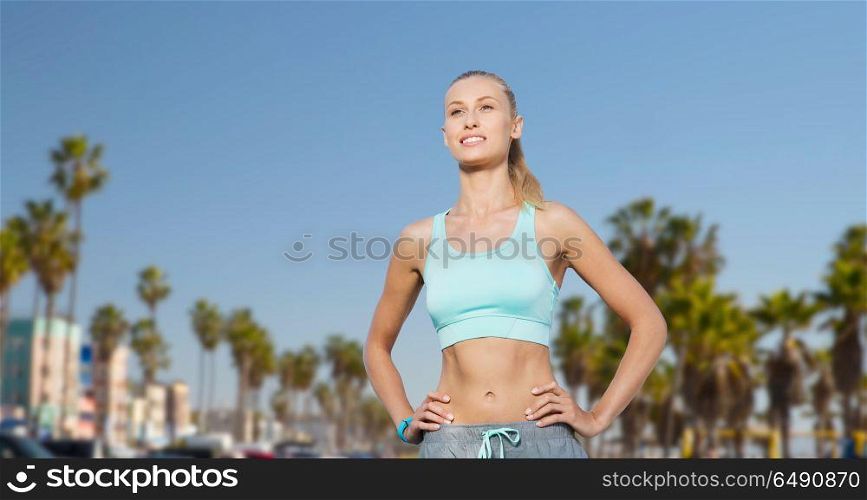 fitness, sport, friendship and healthy lifestyle concept - happy young woman doing sports over venice beach background in california. happy young woman doing sports outdoors. happy young woman doing sports outdoors