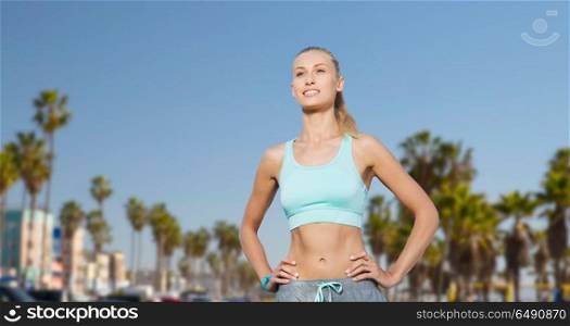 fitness, sport, friendship and healthy lifestyle concept - happy young woman doing sports over venice beach background in california. happy young woman doing sports outdoors. happy young woman doing sports outdoors