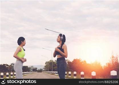 fitness, sport, friendship and healthy lifestyle concept - two happy teenage friends or sportswoman outdoors in park
