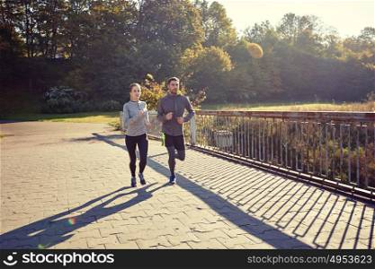 fitness, sport, friendship and lifestyle concept - happy couple running outdoors. happy couple running outdoors