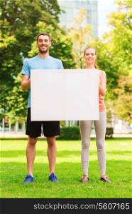fitness, sport, friendship and lifestyle concept - smiling couple with big white blank billboard outdoors