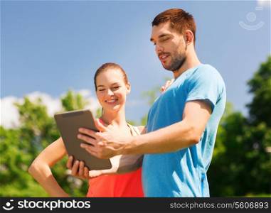 fitness, sport, friendship, technology and lifestyle concept - smiling couple with tablet pc computer outdoors