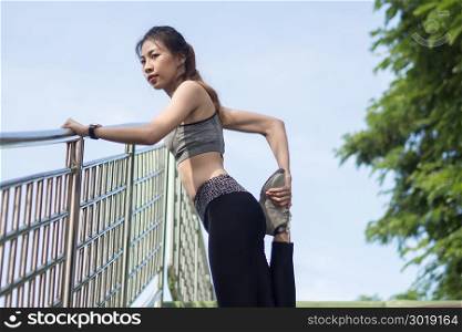 Fitness sport girl fashion sportswear doing yoga fitness exercise in street. Fit young asian woman doing training workout in morning. Young happy asian woman stretching at park after running workout.