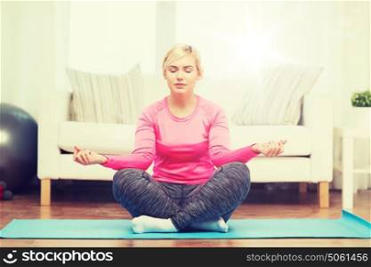 fitness, sport, people and healthy lifestyle concept - happy plus size woman stretching leg on mat at home. happy woman stretching leg on mat at home