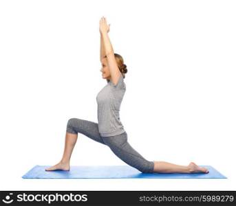 fitness, sport, people and healthy lifestyle concept - happy woman making yoga in low lunge pose on mat