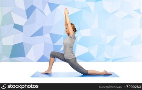 fitness, sport, people and healthy lifestyle concept - happy woman making yoga in low lunge pose on mat over blue polygonal background