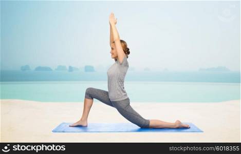 fitness, sport, people and healthy lifestyle concept - happy woman making yoga in low lunge pose on mat over infinity edge pool at hotel resort background