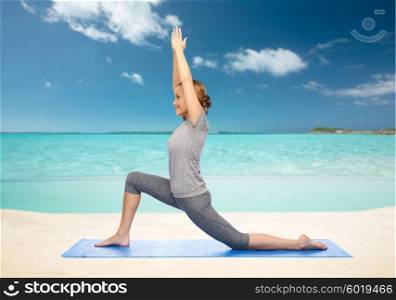 fitness, sport, people and healthy lifestyle concept - happy woman making yoga in low lunge pose on mat over sea and sky background