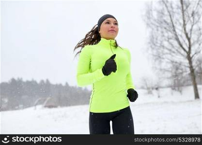 fitness, sport, people and healthy lifestyle concept - happy woman running outdoors in winter. happy woman running outdoors in winter