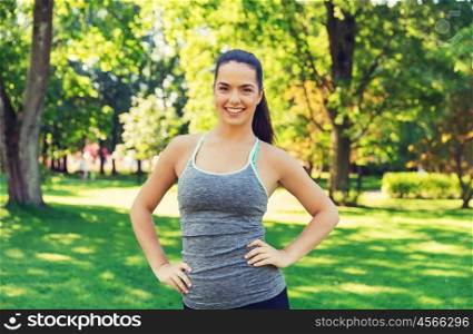 fitness, sport, people and healthy lifestyle concept - happy young woman exercising outdoors