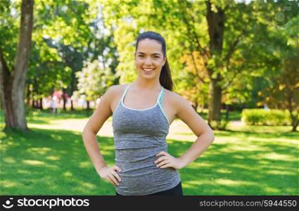 fitness, sport, people and healthy lifestyle concept - happy young woman exercising outdoors