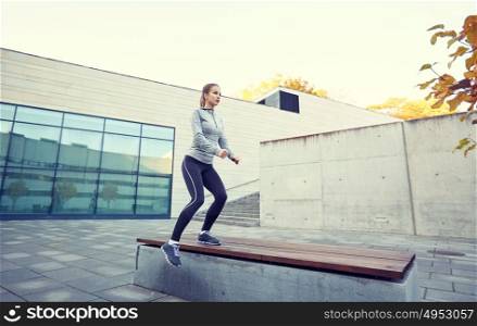 fitness, sport, people and healthy lifestyle concept - woman exercising on bench outdoors. woman exercising on bench outdoors