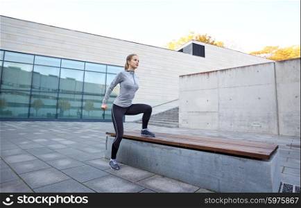 fitness, sport, people and healthy lifestyle concept - woman exercising on bench outdoors