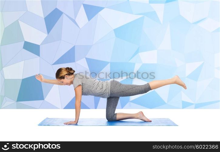 fitness, sport, people and healthy lifestyle concept - woman making yoga in balancing table pose on mat over low poly background