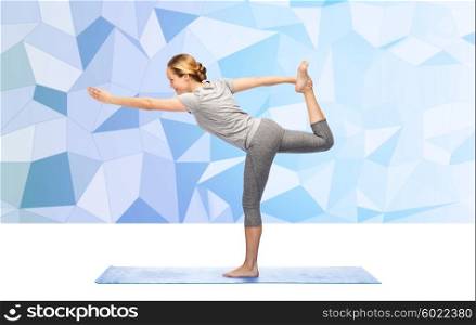 fitness, sport, people and healthy lifestyle concept - woman making yoga in lord of the dance pose on mat over low poly background