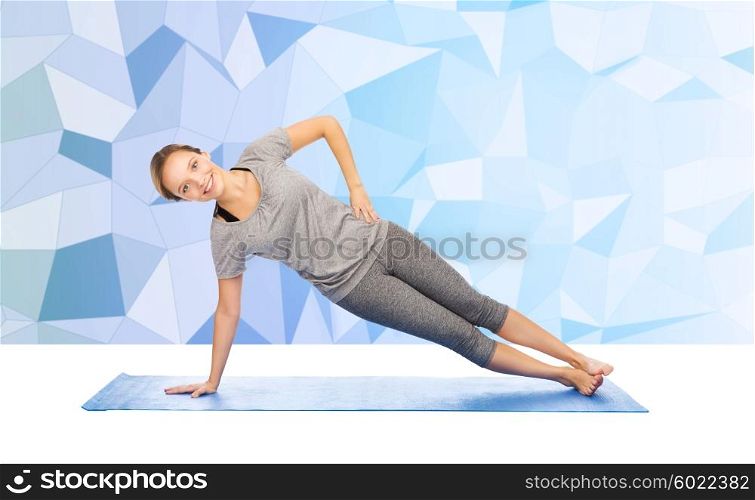 fitness, sport, people and healthy lifestyle concept - woman making yoga in side plank pose on mat over low poly background