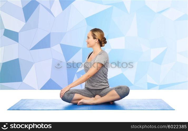 fitness, sport, people and healthy lifestyle concept - woman making yoga in twist pose on mat over low poly background