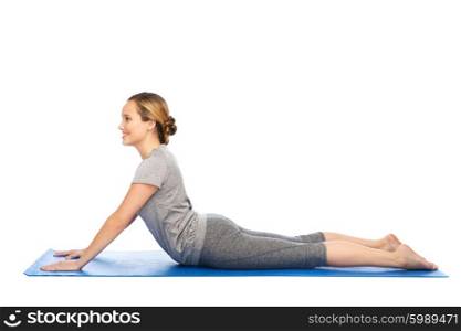 fitness, sport, people and healthy lifestyle concept - woman making yoga in dog pose on mat