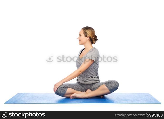 fitness, sport, people and healthy lifestyle concept - woman making yoga in twist pose on mat