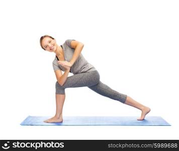 fitness, sport, people and healthy lifestyle concept - woman making yoga low angle lunge pose on mat