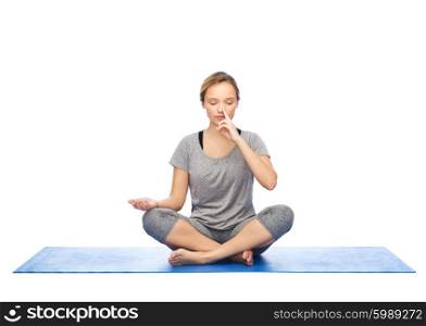 fitness, sport, people and healthy lifestyle concept - woman making yoga meditation in lotus pose on mat