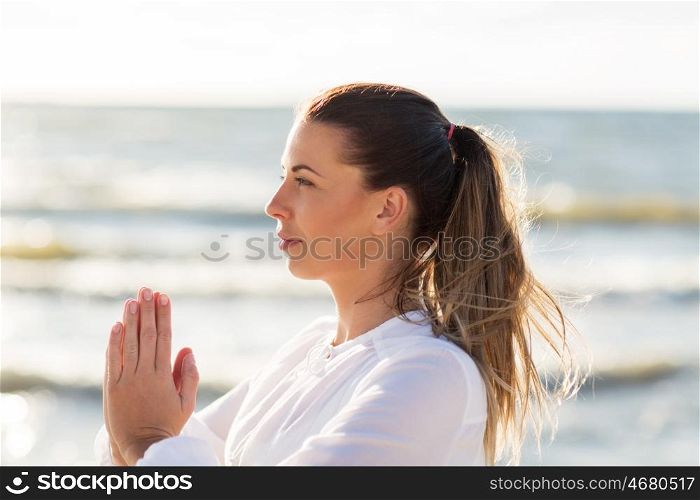 fitness, sport, people and healthy lifestyle concept - woman making yoga on summer beach