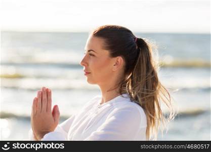 fitness, sport, people and healthy lifestyle concept - woman making yoga on summer beach