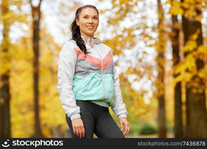 fitness, sport, people and healthy lifestyle concept - young woman in sports clothing at autumn park. young woman in sports clothing at autumn park