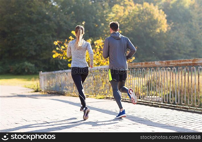fitness, sport, people and jogging concept - couple running or jogging outdoors