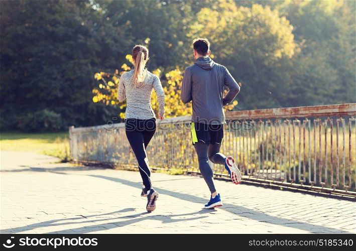 fitness, sport, people and jogging concept - couple running or jogging outdoors. couple running or jogging outdoors