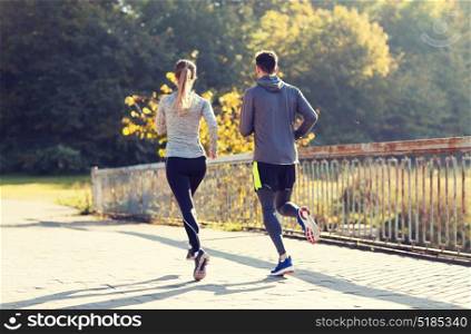 fitness, sport, people and jogging concept - couple running or jogging outdoors. couple running or jogging outdoors