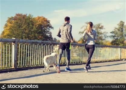 fitness, sport, people and jogging concept - couple with dog running outdoors. couple with dog running outdoors. couple with dog running outdoors