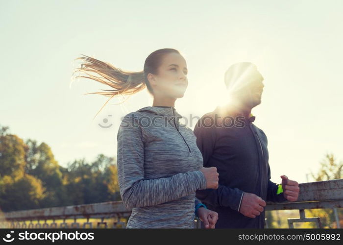 fitness, sport, people and jogging concept - happy couple running outdoors. happy couple running outdoors