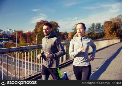 fitness, sport, people and jogging concept - happy couple running outdoors. happy couple running outdoors