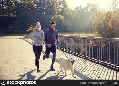 fitness, sport, people and jogging concept - happy couple with dog running outdoors. happy couple with dog running outdoors