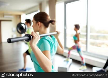 fitness, sport, people and lifestyle concept - close up of sportsmen exercising with bars and step platforms in gym