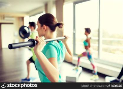 fitness, sport, people and lifestyle concept - close up of sportsmen exercising with bars and step platforms in gym