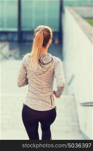 fitness, sport, people and lifestyle concept - close up of sporty woman running downstairs in city. close up of sporty woman running downstairs