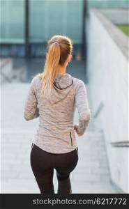 fitness, sport, people and lifestyle concept - close up of sporty woman running downstairs in city