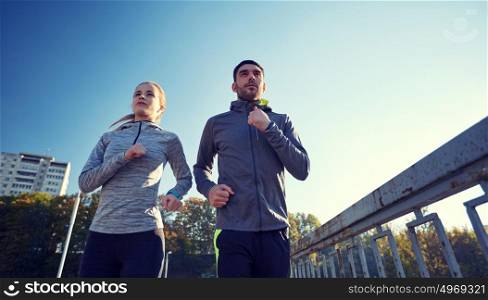 fitness, sport, people and lifestyle concept - couple running outdoors. couple running outdoors