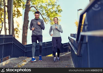 fitness, sport, people and lifestyle concept - happy couple running downstairs in city. happy couple running downstairs in city