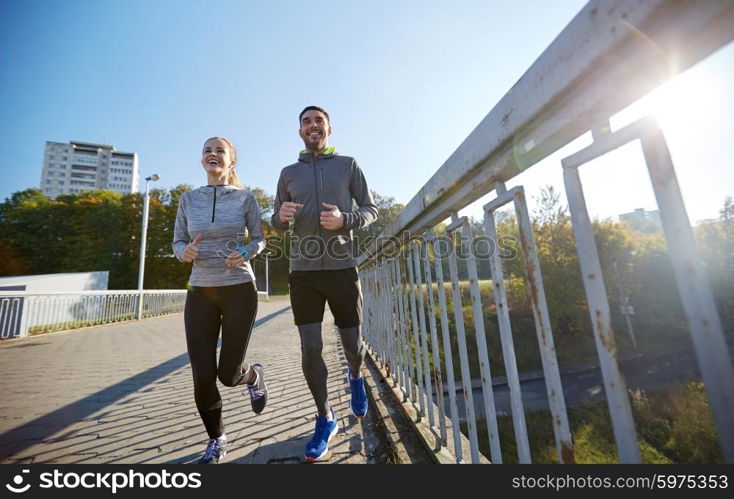 fitness, sport, people and lifestyle concept - happy couple running outdoors