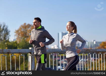 fitness, sport, people and lifestyle concept - happy couple running outdoors